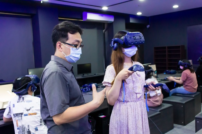 中臺科大教發主任陳韋陸(左)帶領學生體驗 VR未來教室設備