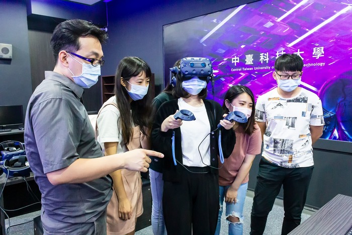 中臺科大教發主任陳韋陸(左1)帶領學生體驗VR未來教室設備圖片