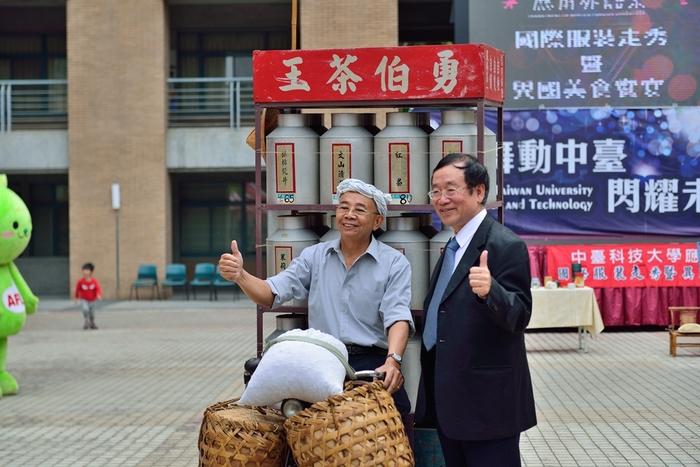 中臺科大李隆盛校長（圖右）與民俗達人朱南山(圖左）合影，達人帶著多年收藏的古董車前來騎乘叫賣，展示了專售茶葉的「茶王自行車」。