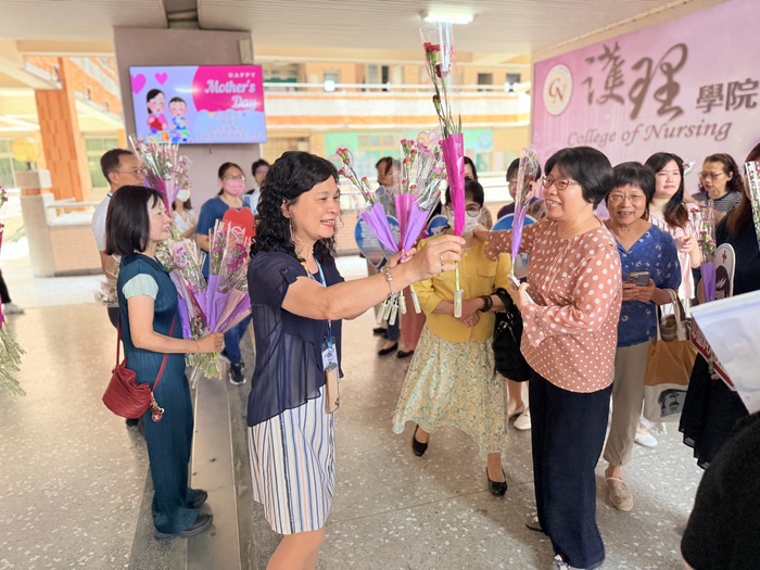 陳錦杏校長親手將一束束精美的康乃馨花束遞送給每一位教職員
