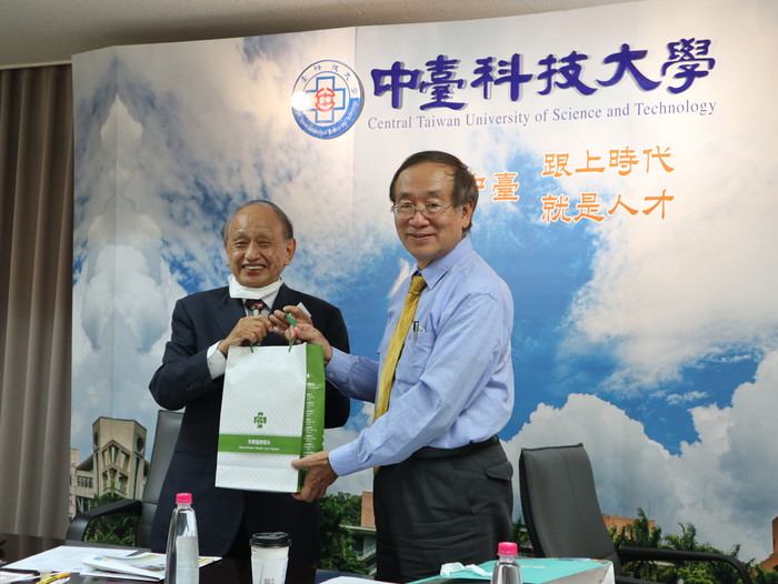 秀傳醫療體系黃明和總裁(左)致贈中臺科大李隆盛校長(右)禮品