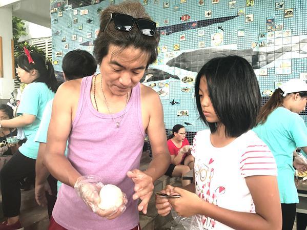 邀請家長與小朋友一起包飯糰，促進親子間互動