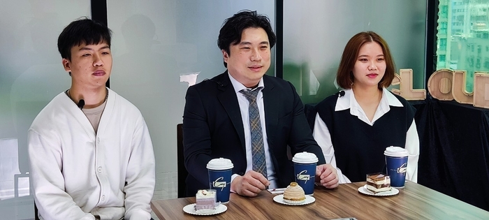 .資管系花丞彥同學(左)及柯嘉愃同學(右)採訪傑出系友李偉業學長(中)