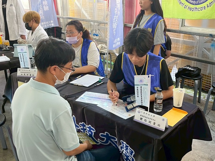 醫管系同學協助里民進行體脂及血糖檢測