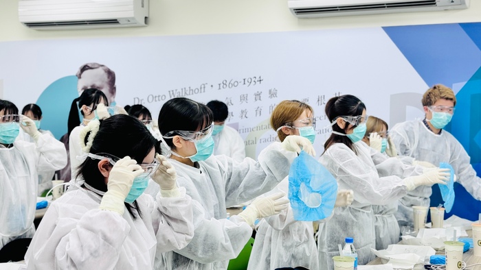 醫放系介紹防護衣功能及讓日本學生體驗穿脫訓練圖片