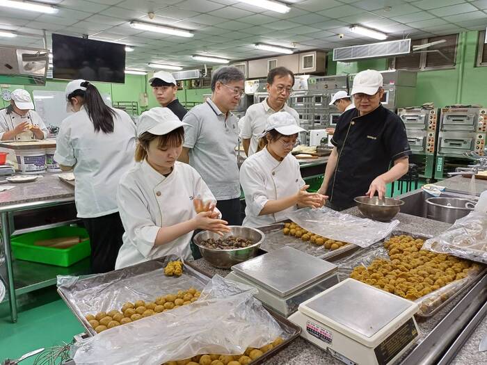 郭炯村老師向鄭副校長及詹主秘解說製作過程