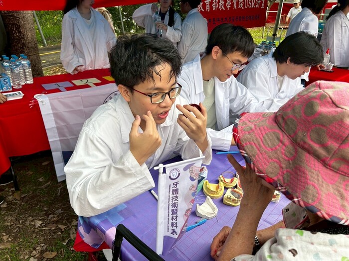 牙技系學生教導民眾牙線正確使用方式