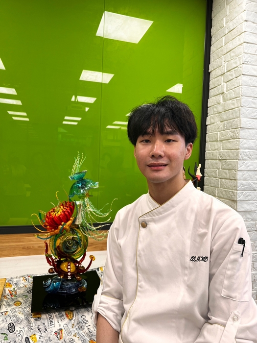 西點製作冠軍得主李哲瑋同學與參賽作品海洋之心合影