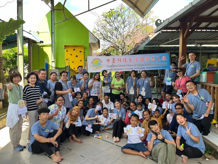 中臺科大印尼志工隊於Yayasan de Legong anak bangsa 早療中心和腦麻孩童一同拿著撕貼畫合影留念