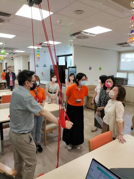 老照系黃建華老師講解並示範操作紅繩懸吊運動系統.pg
